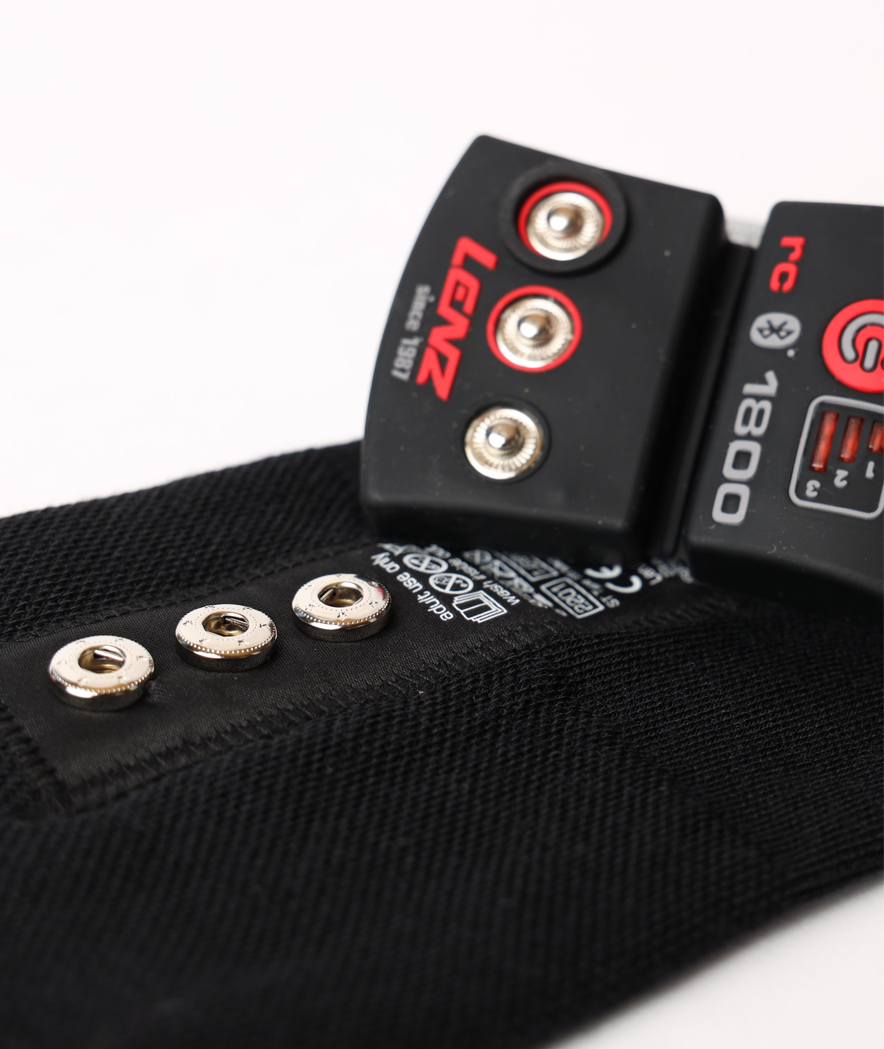 Close-up detail of the metal snap connectors and cuff bracket designed to secure the Lenz lithium battery pack