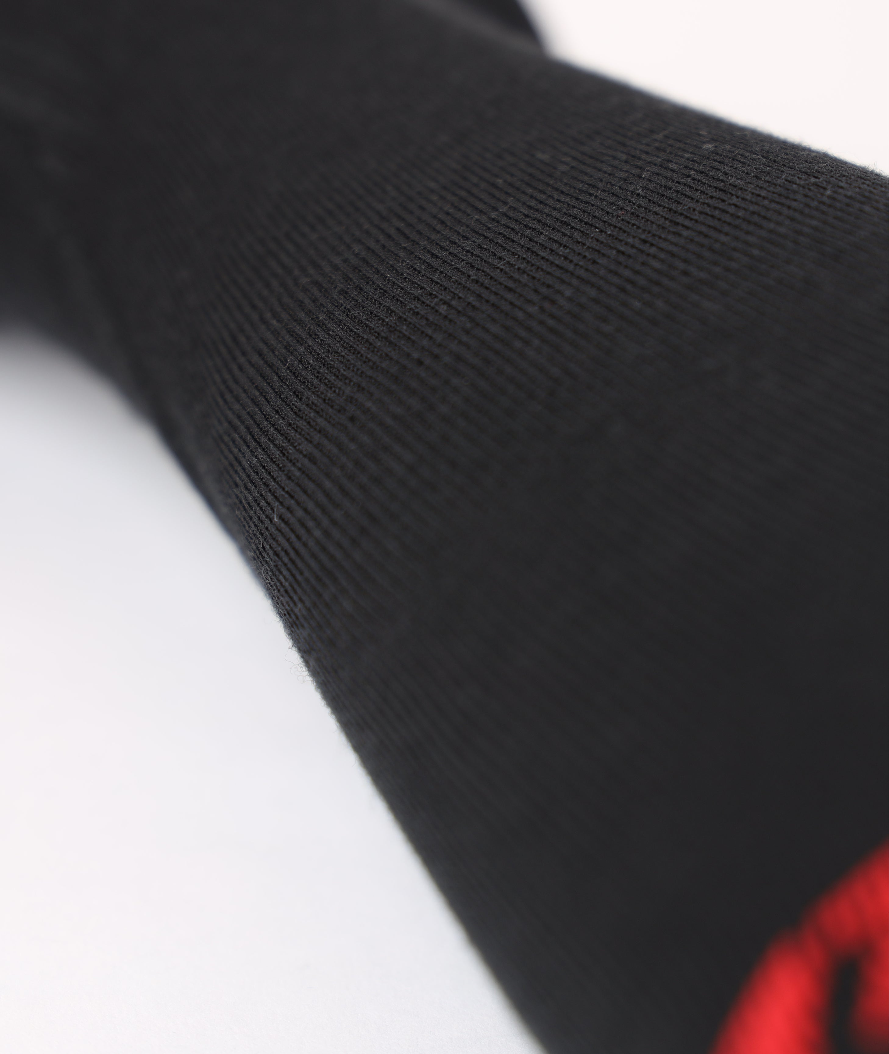 Extreme close-up showing the knit pattern and premium elastic compression fabric texture of the black Lenz ski sock