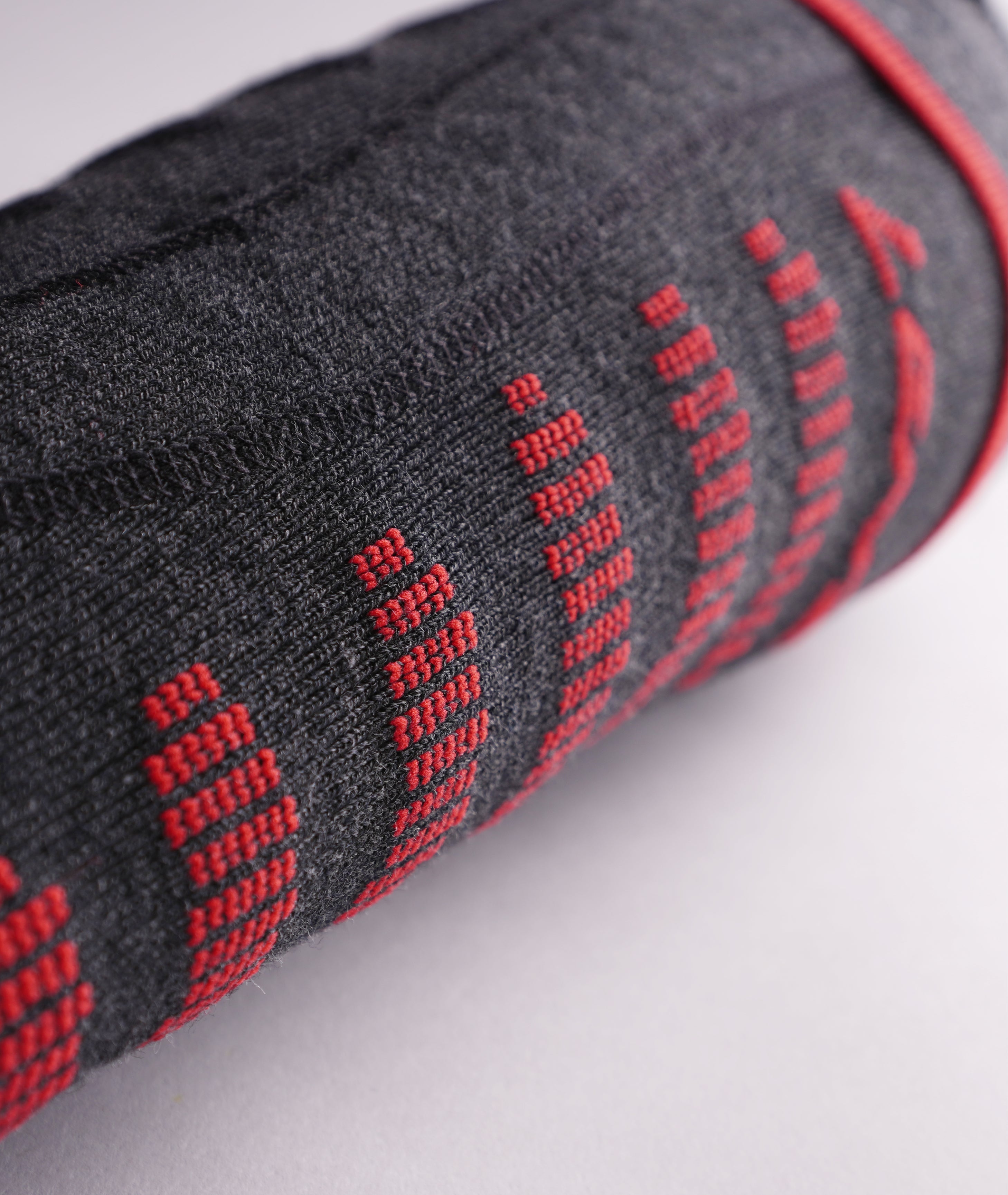 Detailed macro shot of the grey knit fabric texture and red vertical stitching lines on the Lenz 6.1 sock