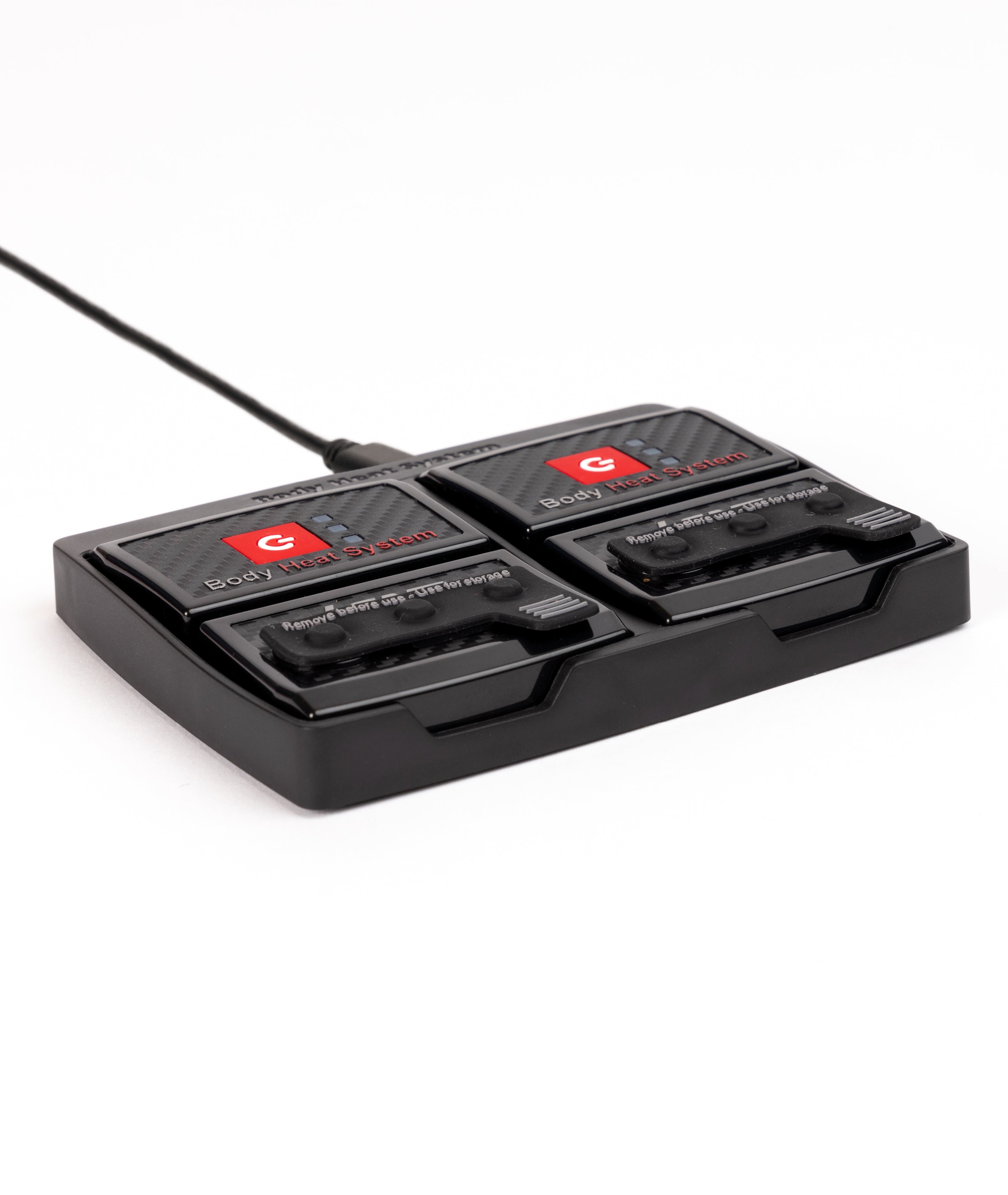 Two black LENZ rcB 1400 battery packs seated in the charging cradle, Body Heat System side up, angled view